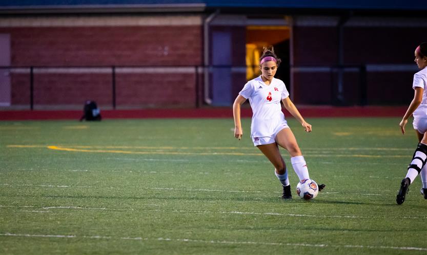A soccer player dribbles the ball